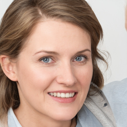 Joyful white young-adult female with medium  brown hair and blue eyes