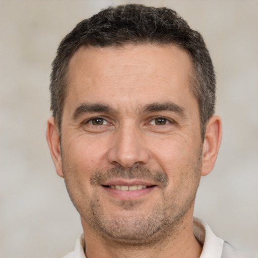 Joyful white adult male with short  brown hair and brown eyes