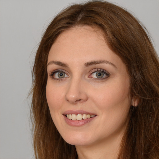 Joyful white young-adult female with long  brown hair and green eyes