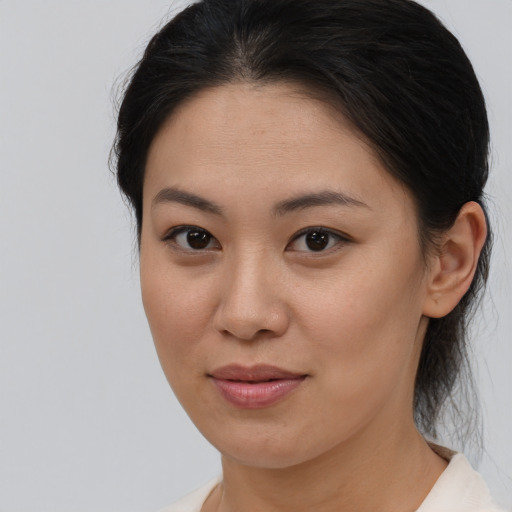 Joyful asian young-adult female with medium  brown hair and brown eyes