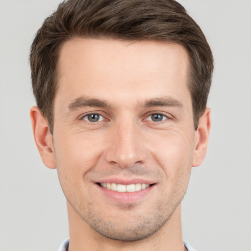 Joyful white young-adult male with short  brown hair and grey eyes