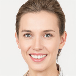 Joyful white young-adult female with medium  brown hair and grey eyes