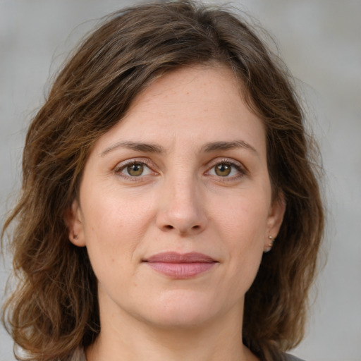 Joyful white young-adult female with medium  brown hair and green eyes