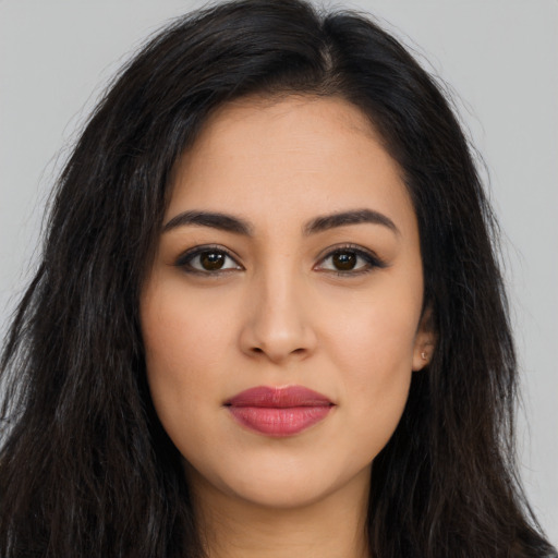 Joyful latino young-adult female with long  brown hair and brown eyes