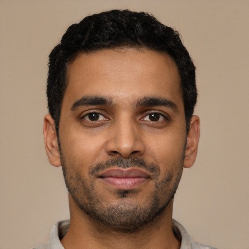 Joyful black young-adult male with short  black hair and brown eyes