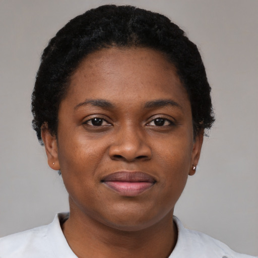 Joyful black young-adult female with short  black hair and brown eyes