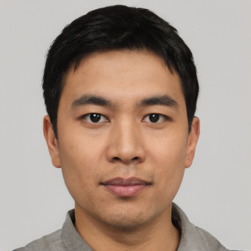 Joyful asian young-adult male with short  black hair and brown eyes
