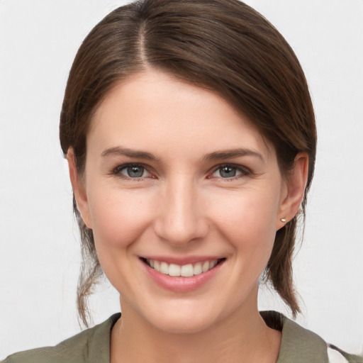 Joyful white young-adult female with medium  brown hair and grey eyes