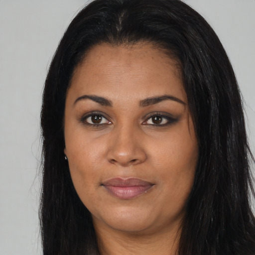 Joyful latino young-adult female with long  black hair and brown eyes