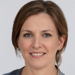 Joyful white adult female with medium  brown hair and grey eyes