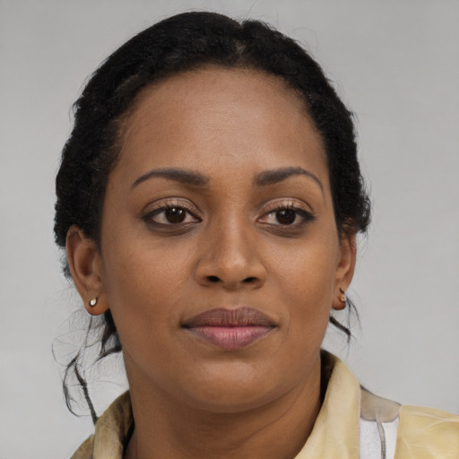 Joyful black young-adult female with long  brown hair and brown eyes
