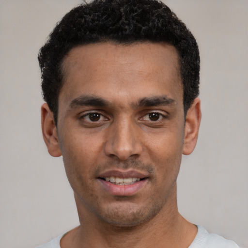 Joyful white young-adult male with short  black hair and brown eyes