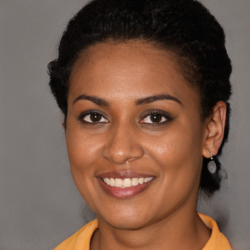 Joyful black young-adult female with short  brown hair and brown eyes