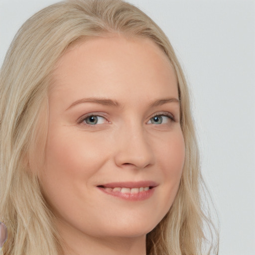 Joyful white young-adult female with long  blond hair and blue eyes