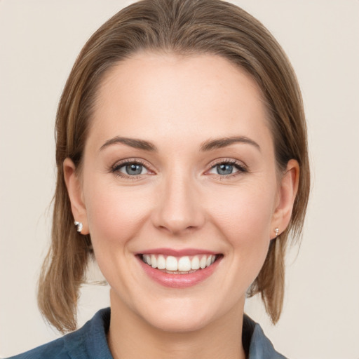 Joyful white young-adult female with medium  brown hair and grey eyes