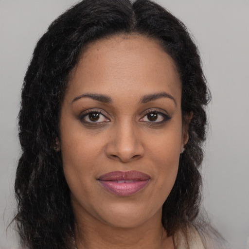 Joyful black young-adult female with long  brown hair and brown eyes