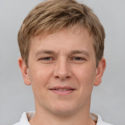 Joyful white young-adult male with short  brown hair and grey eyes