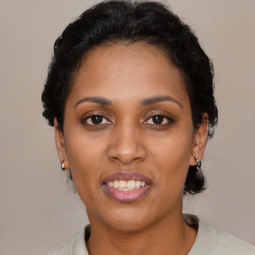 Joyful black young-adult female with short  black hair and brown eyes