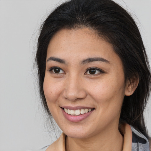 Joyful latino young-adult female with medium  brown hair and brown eyes