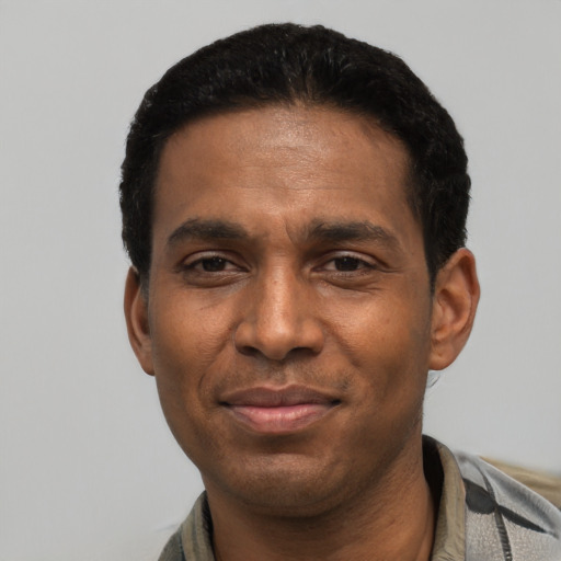 Joyful latino adult male with short  black hair and brown eyes