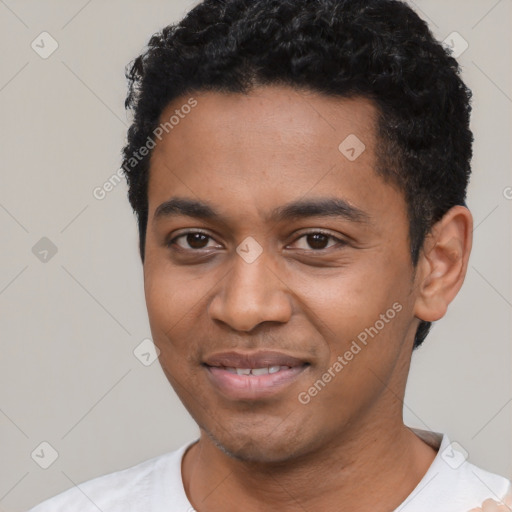 Joyful black young-adult male with short  black hair and brown eyes