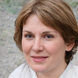 Joyful white adult female with medium  brown hair and brown eyes