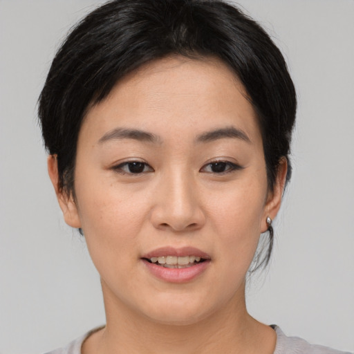 Joyful asian young-adult female with medium  brown hair and brown eyes