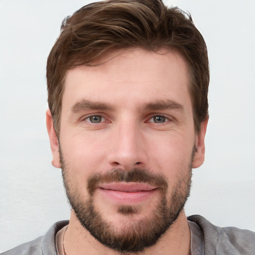 Joyful white young-adult male with short  brown hair and grey eyes