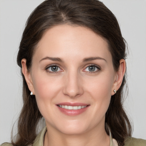 Joyful white young-adult female with medium  brown hair and grey eyes