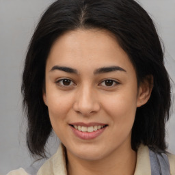 Joyful latino young-adult female with medium  brown hair and brown eyes