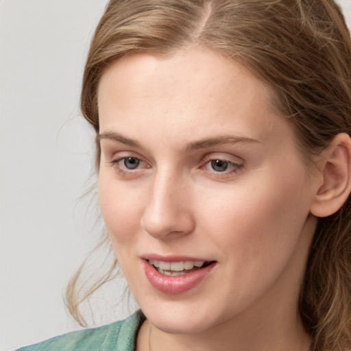 Joyful white young-adult female with medium  brown hair and blue eyes