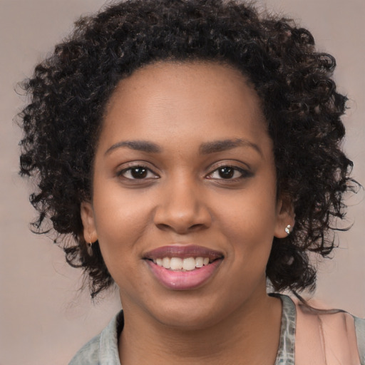 Joyful black young-adult female with long  black hair and brown eyes