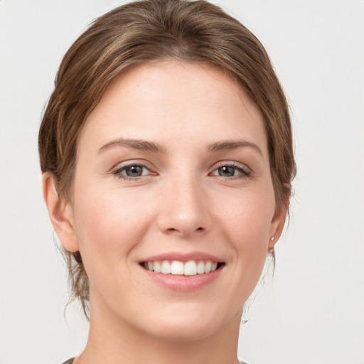 Joyful white young-adult female with medium  brown hair and grey eyes