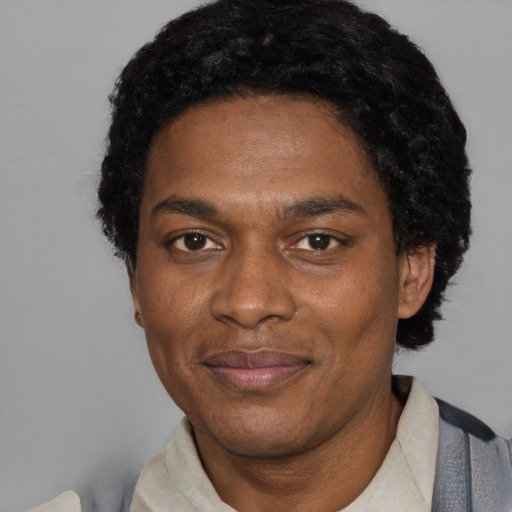 Joyful black adult male with short  black hair and brown eyes
