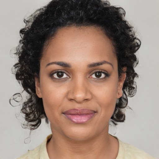 Joyful black young-adult female with medium  brown hair and brown eyes