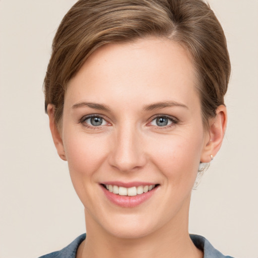 Joyful white young-adult female with short  brown hair and grey eyes