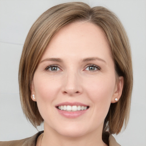 Joyful white young-adult female with medium  brown hair and grey eyes