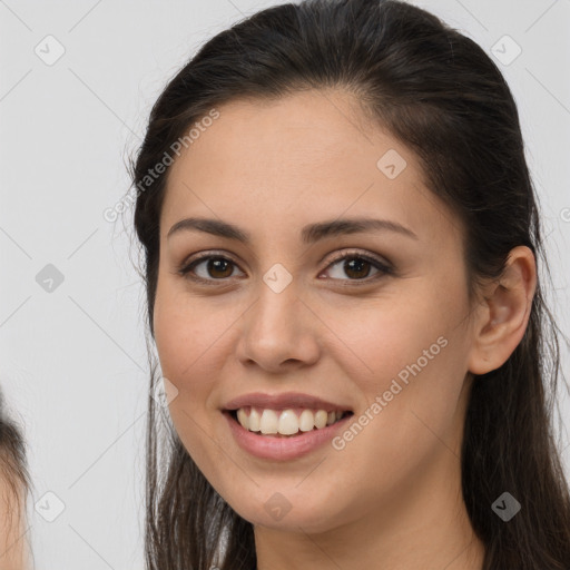 Joyful white young-adult female with long  brown hair and brown eyes