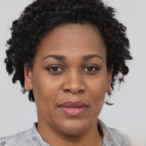Joyful black adult female with short  brown hair and brown eyes