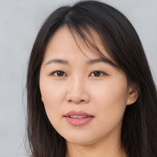 Joyful asian young-adult female with long  brown hair and brown eyes