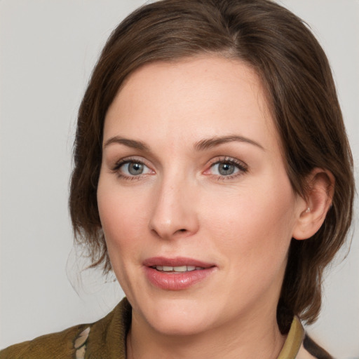 Joyful white young-adult female with medium  brown hair and grey eyes