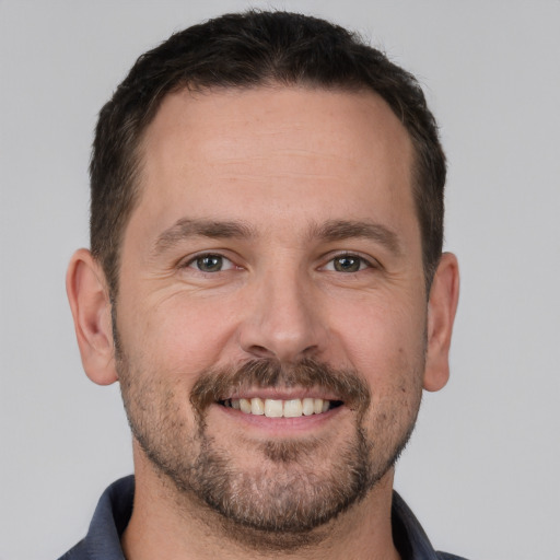 Joyful white adult male with short  brown hair and brown eyes