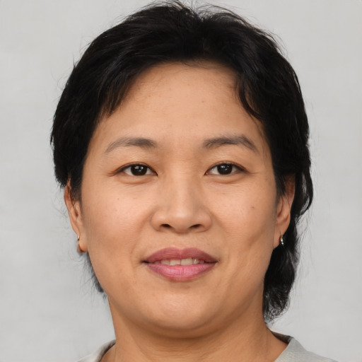 Joyful asian adult female with medium  brown hair and brown eyes