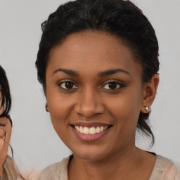 Joyful black young-adult female with medium  brown hair and brown eyes