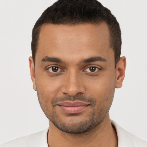 Joyful black young-adult male with short  brown hair and brown eyes