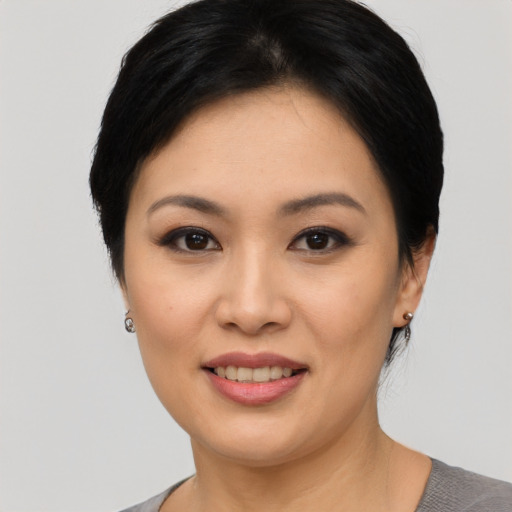 Joyful asian young-adult female with short  black hair and brown eyes