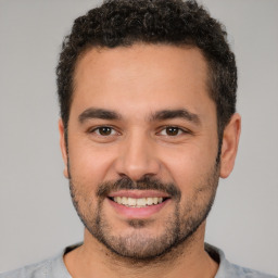 Joyful white young-adult male with short  black hair and brown eyes