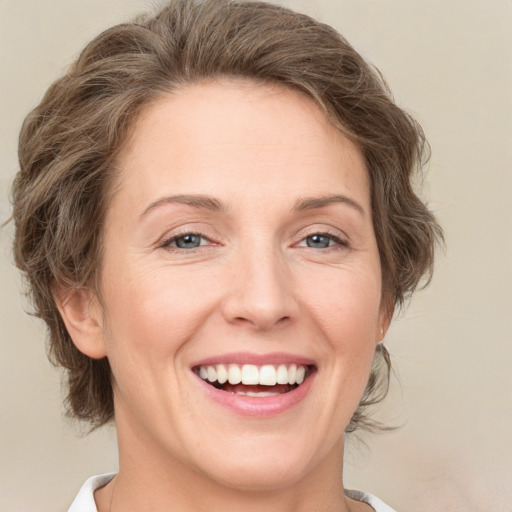 Joyful white adult female with medium  brown hair and green eyes