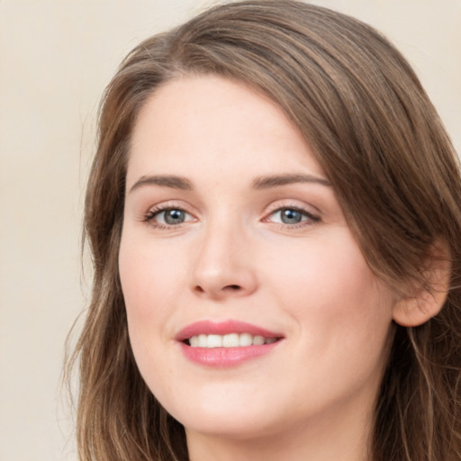 Joyful white young-adult female with long  brown hair and green eyes