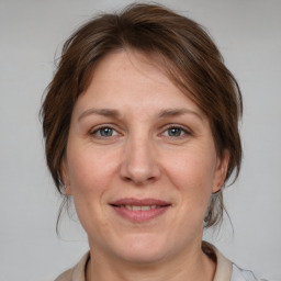 Joyful white adult female with medium  brown hair and grey eyes